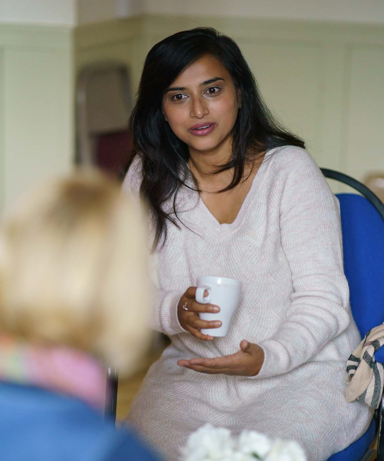 woman holding a hot drink talking