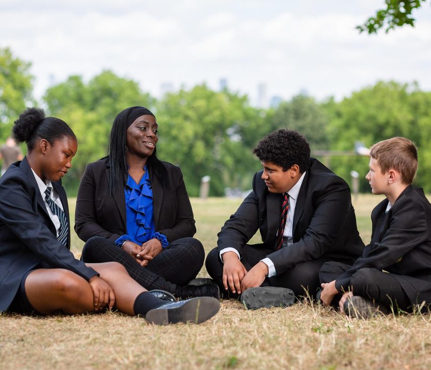 adult and children sitting on a field