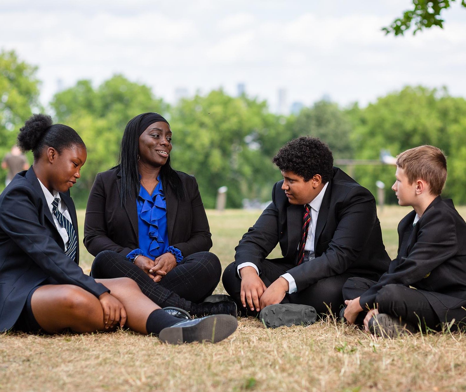 adult and children sitting on a field
