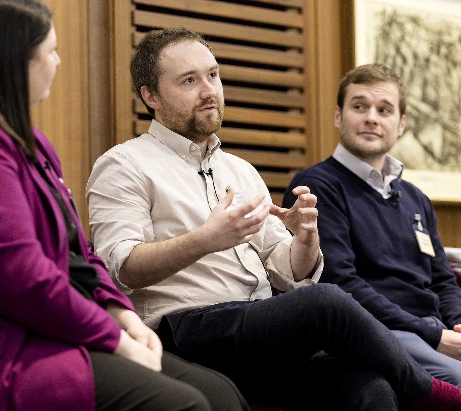 man speaking on a panel during an event