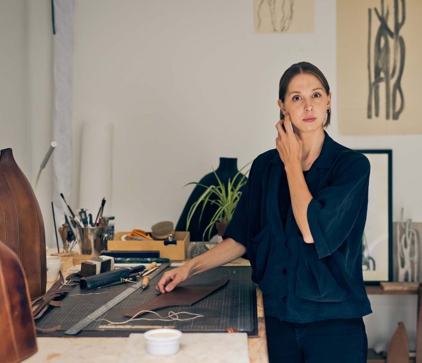 woman in a studio with leather sculptures