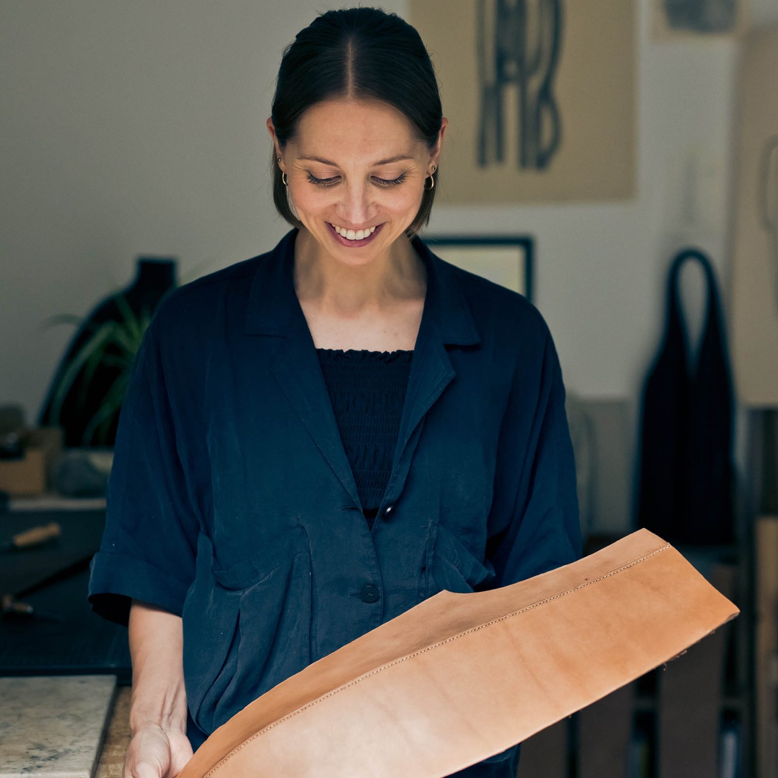 woman holding a leather sculpture