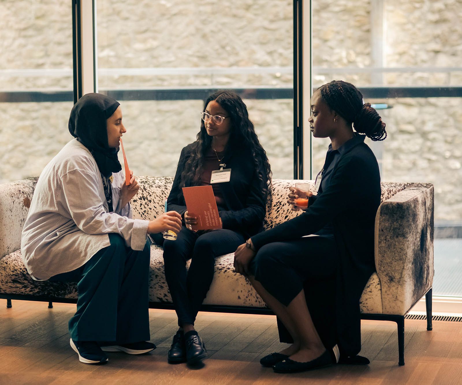 Three women sitting on a sofa talking