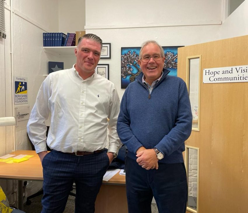 two men standing in an office